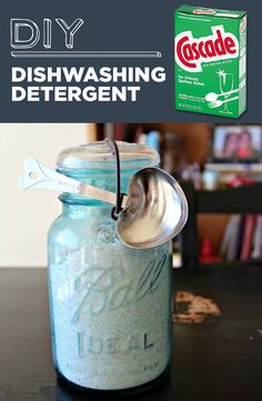 a blue mason jar filled with dishwashing deterant and a spoon in it