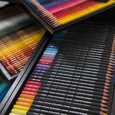 many different colored pencils sitting on top of each other