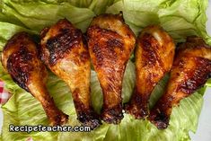 four pieces of chicken sitting on top of lettuce