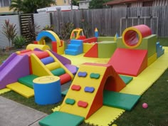 children's play area in backyard with slide, climbing wall and ball pit on grass