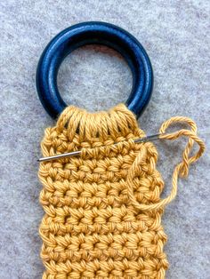 a crochet bag is being worked on with a pair of blue handled scissors