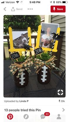 two football vases with pictures on them are sitting on a table in front of a house