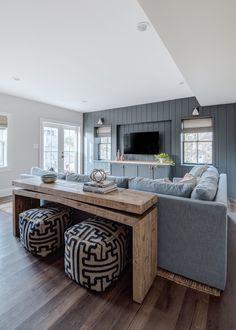 a living room filled with furniture and a flat screen tv mounted to the side of a wall