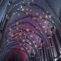 the ceiling is decorated with stars and lights in an old cathedral like building that's very ornate