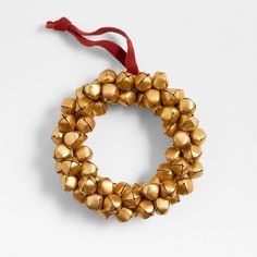 a gold bracelet with bells hanging from it's side on a red ribbon against a white background