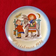 a plate with an image of two children on it sitting on a wooden table next to a wall