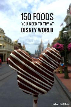 a chocolate heart shaped lollipop with the words 150 foods you need to try at disney world