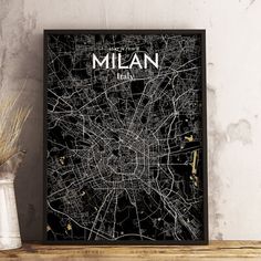 a black and white map of the city of milan, italy on a wooden shelf