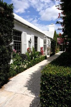 a white house surrounded by greenery and flowers