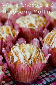 white chocolate and raspberry muffins with icing on a cooling rack