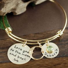 "Check out our Website: ANNIEREH.COM Love you to the moon and back Bracelet, Gold Bangle Charm Bracelet, Gold Name Bracelet, Moon and Back Bangle, Kids Names, Engraved Jewelry This adjustable bracelets is designed to be worn individually or stacked with other bangle bracelets. One size fits all. This listing COMES with the phrase disc, the moon charm and ONE name and ONE birthstone. Add more during check out. Love you to the moon and back gold pendant is stamped with our adorable saying... I lov Gold Name Bracelet, Charm Bracelet Gold, Birthstone Colors, Kids Names, Gold Disc, Gold Moon, Bangle Bracelets With Charms, To The Moon And Back, Gold Bangle Bracelet