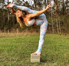 a woman is doing yoga outside in the grass