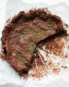 a chocolate cake with one slice cut out and sprinkled with spices on top