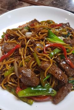 a white plate topped with beef and noodles