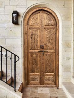 an ornate wooden door with wrought iron handrails