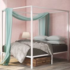 a bed with a canopy and pillows in a pink room next to a wooden floor