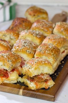 a wooden cutting board topped with cheesy bread