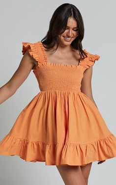 Get ready to turn heads in the Brynlee Mini Dress! This vibrant orange dress is perfect for any occasion, whether you're heading to brunch with friends or a casual day at the office. The elastic chest and flutter sleeve hem add a flirty touch, while the square neckline and fit & flare silhouette create a flattering shape. Made from comfortable cotton fabric, this dress will keep you cool and comfy all day long. Embrace your individuality and express yourself with this empowering mini dress that Orange Ruffle Hem Dress For Brunch, Orange Sundress With Smocked Bodice, Orange Dress With Smocked Bodice For Day Out, Orange Ruffled Sundress For Vacation, Orange Sundress With Smocked Back, Orange Ruffled Sundress, Orange Sundress With Ruffles, Orange Ruffle Mini Dress For Vacation, Orange Mini Dress With Ruffle Hem For Summer