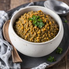 a white bowl filled with lentils and garnished with parsley