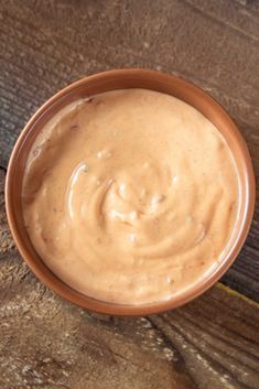 a brown bowl filled with peanut butter on top of a wooden table