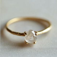 a gold ring with a white diamond on it