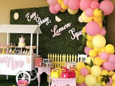 a pink and yellow dessert cart is in front of a backdrop that says happy lemon spring