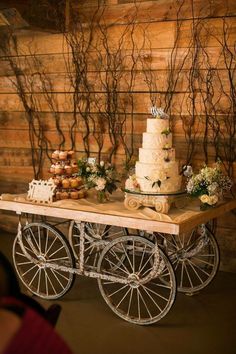 a table topped with a cake and cupcakes on top of a wooden table