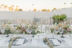 the table is set with silverware and white linens for an elegant wedding reception