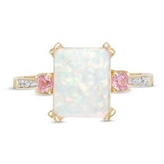 Fashioned in 10K gold, this three stone ring features a 10.0 x 8.0mm emerald-cut lab-created opal center stone flanked on either side by two lab-created pink sapphires with diamond accents lining the ring's shank. Fine Jewelry With Three Stone Rectangular Design, Fine Jewelry Rectangular Three Stone, White Radiant Cut Three Stone Jewelry, Fine Jewelry Rectangular Three-stone, White Opal Three Stone Ring As Gift, White Three Stone Opal Ring Gift, White Radiant Cut Jewelry With Accent Stones, Gold Emerald Wedding, Frame Ring