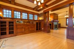 an empty living room with wood paneling and large windows