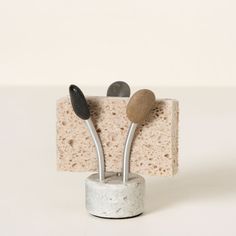 three stones are placed on top of each other in a small holder that is made out of concrete