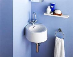 a bathroom with blue walls and a white sink in the corner next to a towel rack