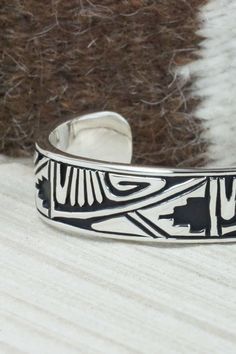 This sterling silver and bracelet was made by Navajo silversmith Kerry Begay. The inside is signed KB and stamped sterling.Size: 5" (will fit up to a 6" wrist)Gap: 1"Width: 1/2"Free shipping on all orders! We ship with USPS and always include tracking. All orders ship within a day of payment.Returns are accepted up to 30 days after you receive your order. Just send us a message. Our shop offers cash back or store credit. The item must be returned in new condition. Southwestern Sterling Silver Bracelet Stamped 925 As Gift, Artisan Sterling Silver Bangle Bracelet, Unique Etched Sterling Silver Adjustable Bracelet, Unique Adjustable Etched Sterling Silver Bracelet, Unique Etched Adjustable Sterling Silver Bracelet, Etched Sterling Silver Bracelet In Traditional Style, Unique Etched Sterling Silver Bracelets, Etched Sterling Silver Cuff Bracelet, Artisan Sterling Silver Bracelet With Polished Finish