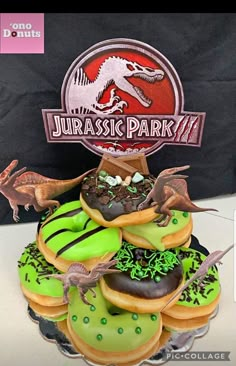 there is a dinosaur themed cake on top of donuts