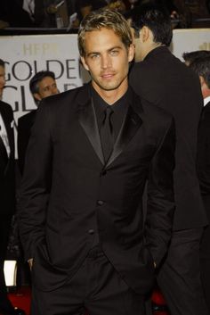 a man in a tuxedo and black suit at the golden globe awards on red carpet