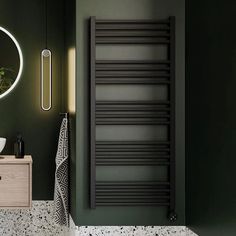 a bathroom with green walls and a round mirror above the sink, along with a towel rack