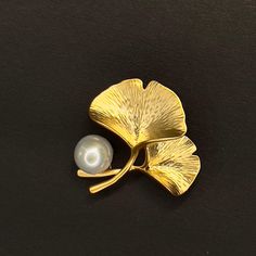 Looking for a unique, classy & chic token of love and well wishes? Our delicate handmade gold gingko leaf brooch with freshwater pearl is the perfect gift choice. The gold leaf is delicately brushed to give an elegant texture and the freshwater pearl embedded on top will softly shine. 👌 M A T E R I A L • Gold plated over brass• High quality freshwater pearls• This product is hypoallergenic (nickel free) and tarnish resistant 📏 S I Z E • 0.75 inch x 0.95 inch (About a quarter coin size) Elegant Leaf-shaped Brooches For Gifts, Gold Leaf Brooch For Gift, Elegant Texture, Gingko Leaves, Pearl Gifts, Brass Pin, Lotus Leaves, Gold Brooch, Leaf Brooch