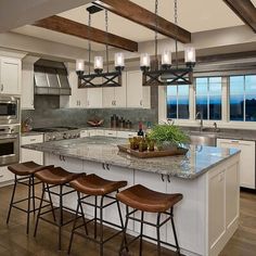 a kitchen with an island and four stools in front of the stove top oven