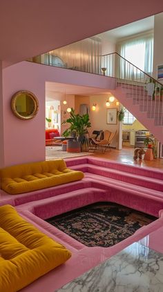 a living room filled with pink couches and yellow pillows next to a stair case