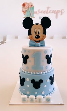 a mickey mouse cake with the number one on it's top and ears sticking out