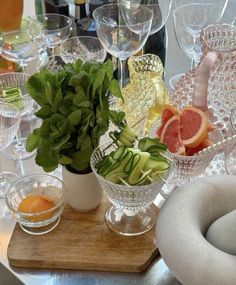 a table topped with glasses filled with different types of fruit and vegtables