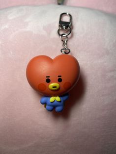 a heart shaped keychain with a cartoon bear on it's chest, hanging from a metal chain