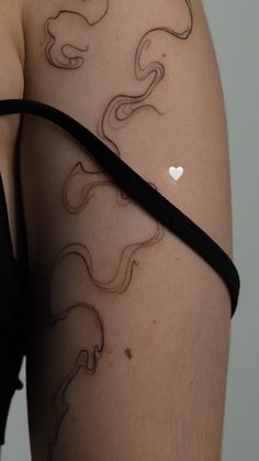 a woman's thigh with tattoos on it and a white heart in the middle