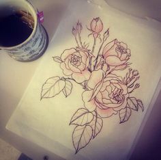 a drawing of flowers on paper next to a cup of coffee