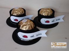 three hats with gold foiled ladybugs on them are sitting next to each other