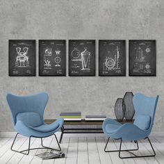 two chairs and a coffee table in front of a wall with three drawings on it