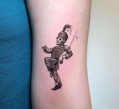 a small tattoo of a skeleton holding a baseball bat on the right side of the arm