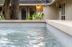 an empty swimming pool in front of a house