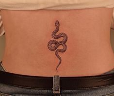 a woman's stomach with a snake tattoo on her lower back and the side