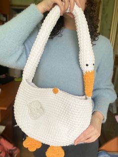 a woman holding a knitted purse with two ducks on the front and one duck on the back